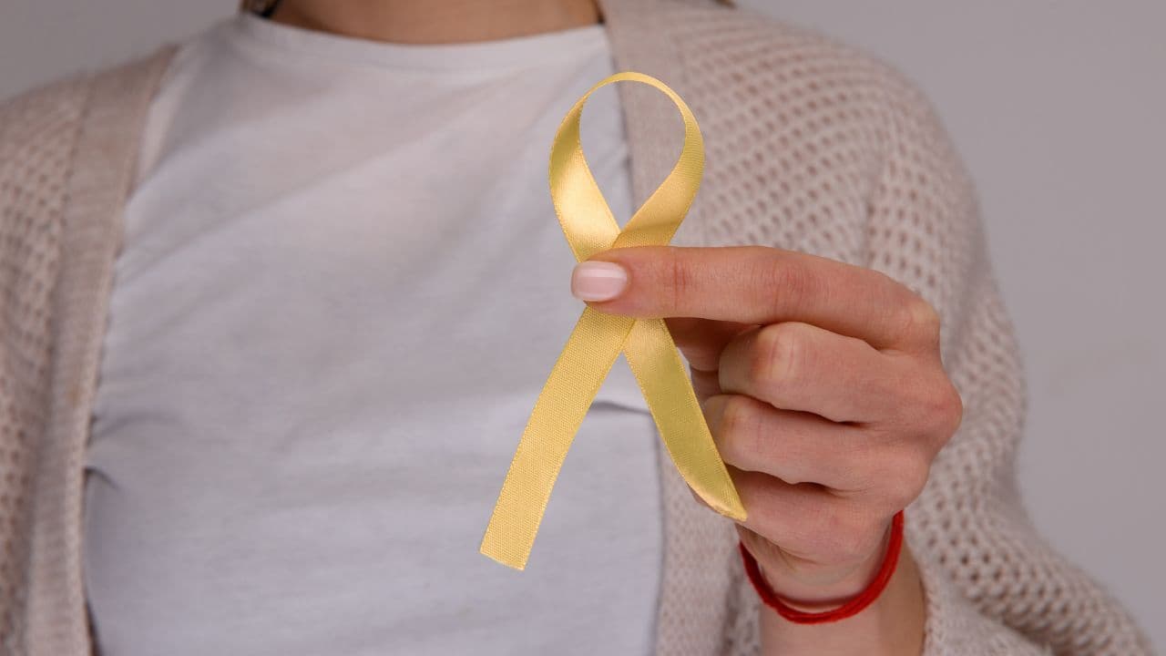 Woman holding a yellow endometriosis awareness ribbon